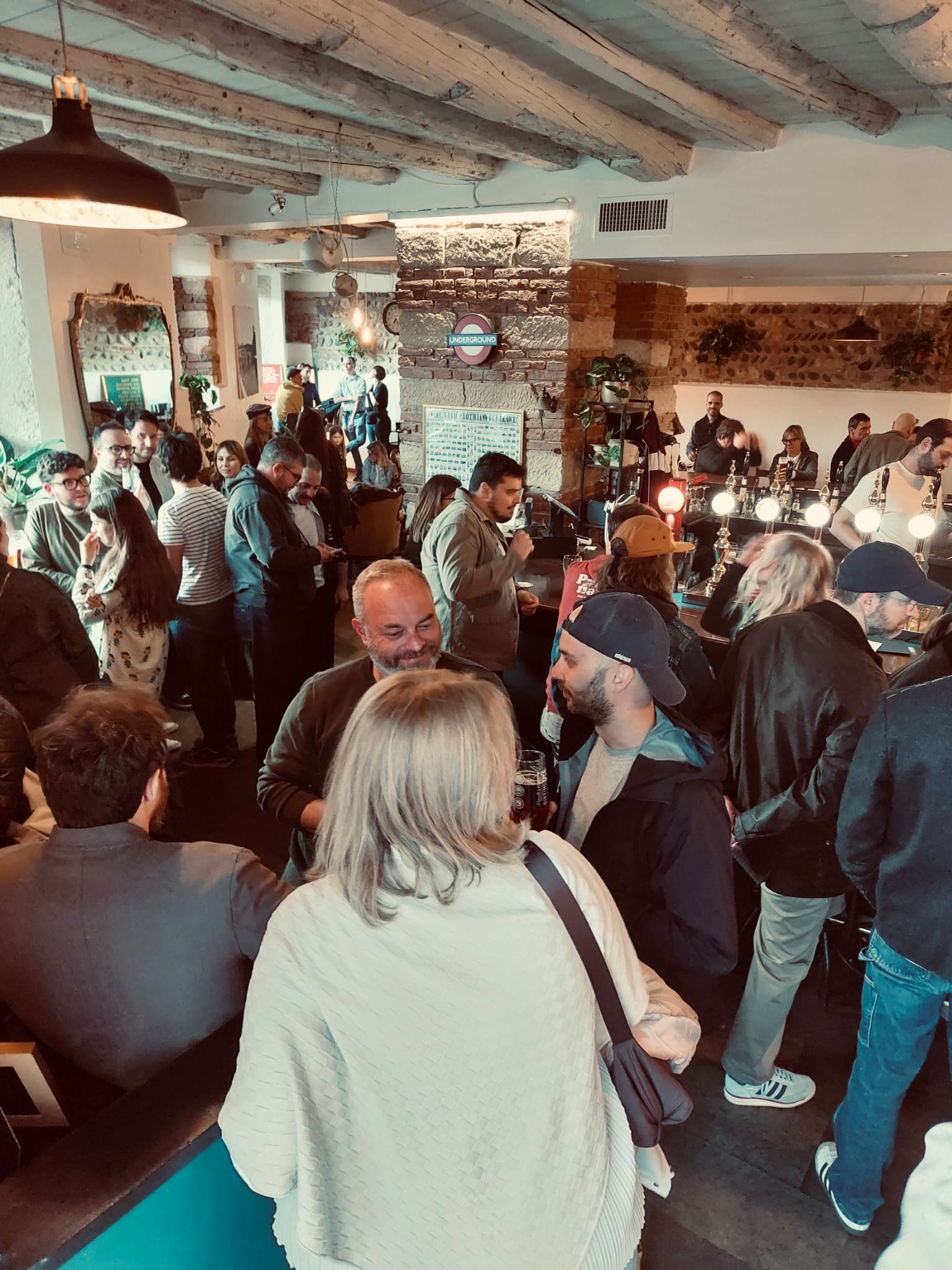 Tavoli e bancone del pub con clienti in conversazione